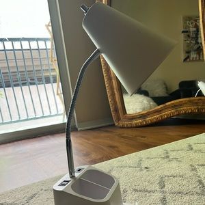 A lightly used desk lamp that has storage organizers, USB ports, and a lightbulb